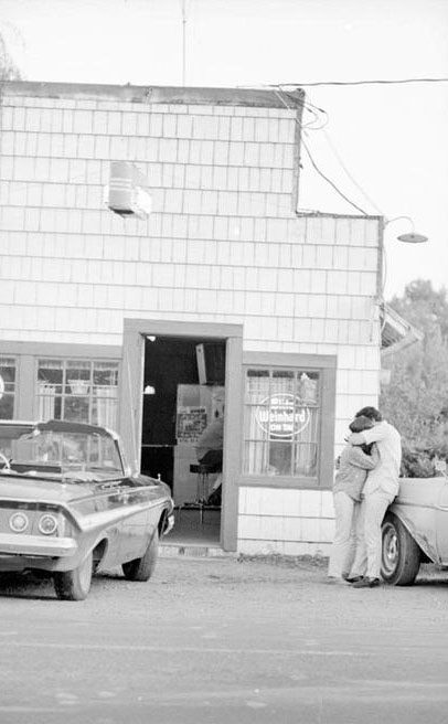 A outdoor candid portrait of a couple hugging in front of the Alpine Tavern in Alpine, Oregon., James Cloutier photographs, 1977