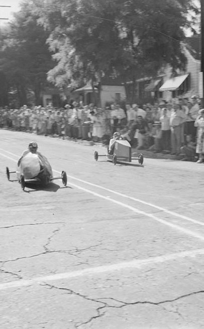 Two boys in soap box cars race down a street., Lee D. Drake (1882-1957) photographs, ca. 1910-1957