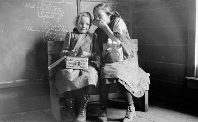 An indoor portrait of two schoolgirls eating lunch, Roy C. Andrews photographs, 1902-1955