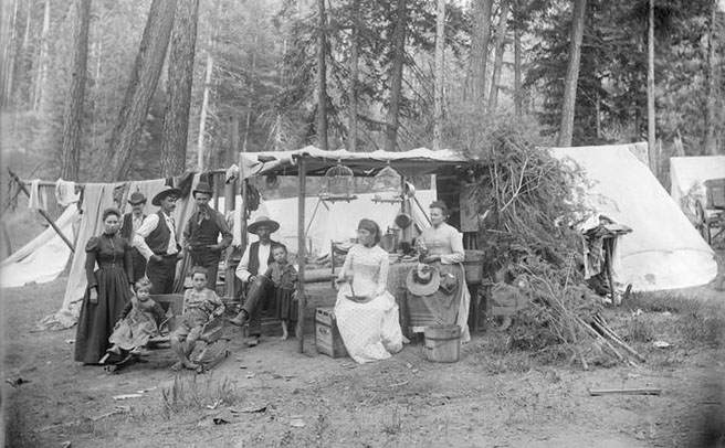 Four men, three women, and three children pose outdoors in front of a campsite., Walter S. Bowman (1865-1938) photographs, 1880s-1920s
