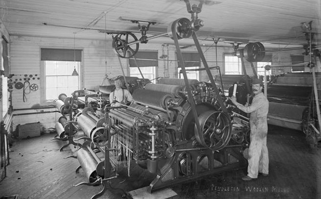 Two men pose next to textile machinery in Pendleton Woolen Mill, Walter S. Bowman (1865-1938) photographs, 1880s-1920s