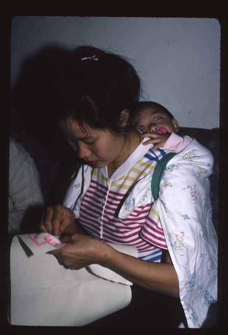 Master Artist Lao Mee Vang working with apprentice Sue Vang on Hmong Embroidery at Sue Vang's house