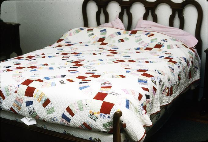 70 x 88 inch Double Wedding Ring Quilt made by Minnie Belle Slemmons in St. Louis, Montana. She was from Kentucky before that. Quilt was probably made in 1920s. Minnie Belle Slemmons died in 1935 (mother)