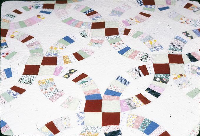 70 x 88 inch Double Wedding Ring Quilt made by Minnie Belle Slemmons in St. Louis, Montana. She was from Kentucky before that. Quilt was probably made in 1920s. Minnie Belle Slemmons died in 1935 (mother).