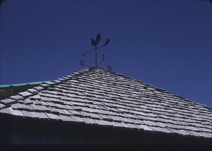 Cock weathervane atop roof, long view