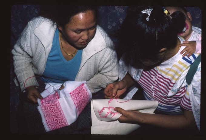 Master Artist Lao Mee Vang working with apprentice Sue Vang on Hmong Embroidery at Sue Vang's house