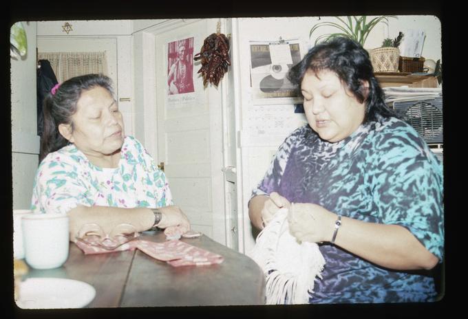 Master Artist Margaret Pennah working on root digging bag with apprentice Elizabeth Woody at Mrs. Pennah's home
