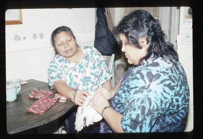 Master Artist Margaret Pennah working on root digging bag with apprentice Elizabeth Woody at Mrs. Pennah's home