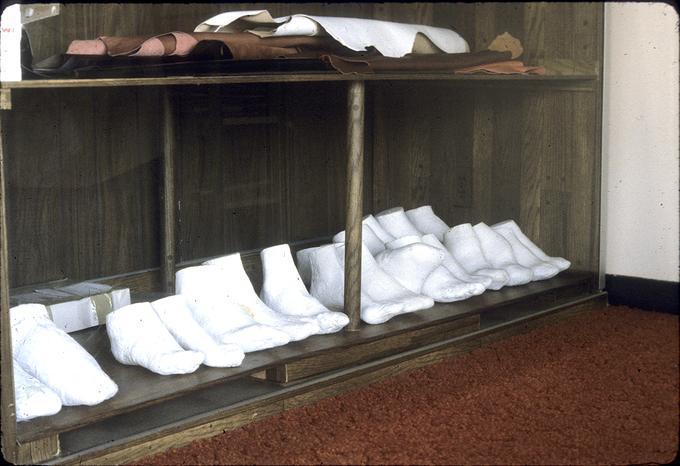 Row of plaster molds of feet on display in front case of Mr. S's shop