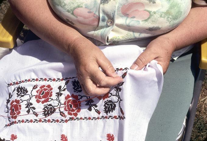 Pictures of Mrs. Shalduha embroidering, showing how the sleeve will look on her arm.