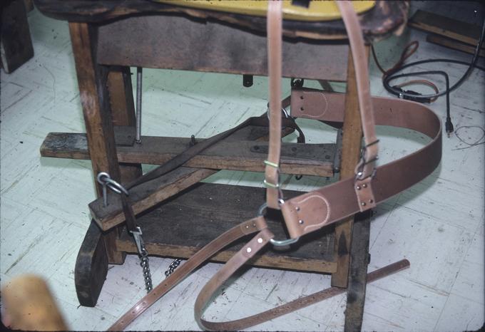 Base of hold-down saddle stand