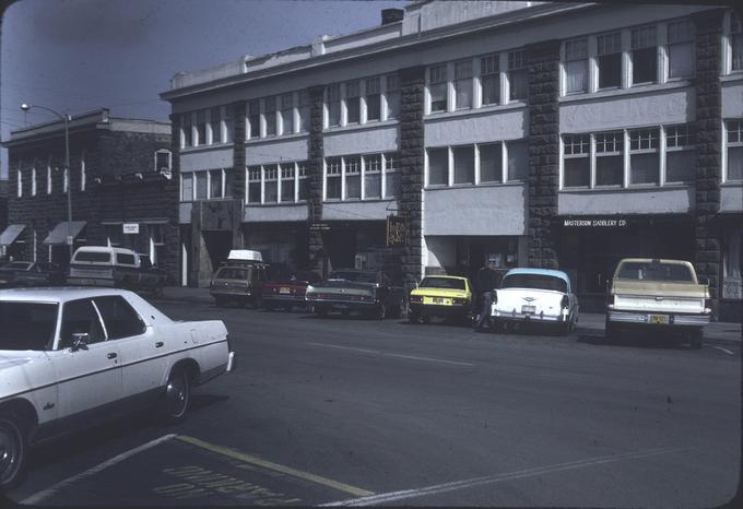 Row of shops on north side of Enterprise square, including saddlery