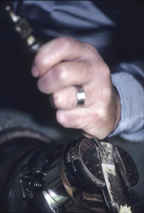 Mr. Robert Valade at work on knife handle tip, detail of chasing, front view