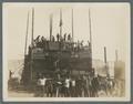 Students posing in front of students constructing the bonfire