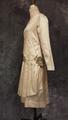 Wedding dress of ivory silk satin with flower corsage of woven silver fabric at side hip