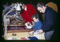 Boy and father examining bourse table at coin show, San Jose, California, January 1972