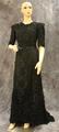 Dress of black silk with overlay of heavy weight net lace with applique