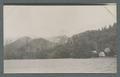 Houses and hills viewed from a river, circa 1910