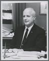 James H. Jensen seated at desk, circa 1965