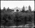 State Training School buildings on hill in background, Salem, with wood stairway leading into ravine. Willamette River in foreground.