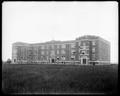 Brick classroom building on campus of Columbia University (Portland University), Portland. Field in foreground.