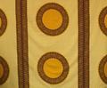 Textile Panel of yellow, maroon and navy wax cotton print with three large circles blocked by geometric borders