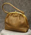 Purse-style handbag of honey brown pebbled leather with gold frame and clasp at top