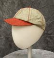 Baseball cap speckled blue-gray wool with stitched bright red visor and bright red piping and button at top of crown