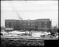 Failing School, Portland, under construction, final stage. Full front view of building. Construction debris in foreground.