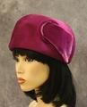 Hat of magenta piled felt with circular jewel at side