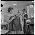 Home Economics students examining garments in a clothing and textiles research lab, February 1964