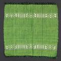 Napkin of hand-woven green and black cotton with white silk added weft geometric designs blocked by white woven stripes