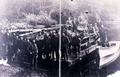 Several men on dock or barge at edge of river