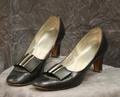 Pumps of black leather with silver buckle accent on vamp