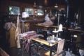 Elmer's shop, interior of work room, Elmer at counter carving leather