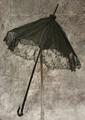 Parasol of black silk with overlay of fine tulle lace that drapes over the edge