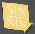 Textile fragment of golden yellow woven cotton embroidered or brocaded in pale grey silk