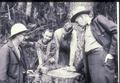 People examining growth rings on stump