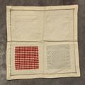 Textile Sampler of white linen with two fabric insertions of red and white check and grey-blue polka-dot