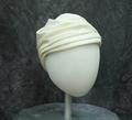 Toque style hat of ivory woven fabric that is stiffened