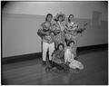 Students in Hawaiian dress posing with ukuleles at an international student reception