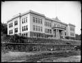 Astoria High School, Astoria, OR., with stone wall in foreground below school.
