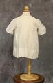 Child's Dress of white cotton with pin pleats and needlework at the front yoke