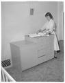 A Home Economics student preparing a changing table in the Kent House, May 1958