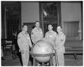 Participants in a Summer Session reception and open house posing with an oversized globe, Memorial Union