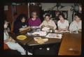 Theresa Mae Eagle (Master Artist) and apprentices sit around a table working on beading