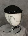 Bumper-style hat of black felt with braided cord looped embellishment