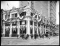 Merchant's National Bank, Washington St., Portland. Building and street decorated for Rose Festival. Pedestrians in street, two boys with bicycle on corner.