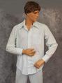 Shirt of pale blue cotton cambric with a geometric woven pattern that is sheer in the design areas