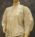 Blouse of white cotton has standing band collar with pin tucks